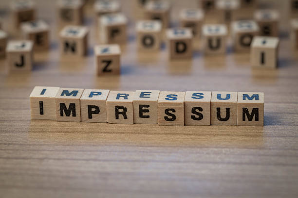 Impressum (German Imprint) written in wooden cubes on a table